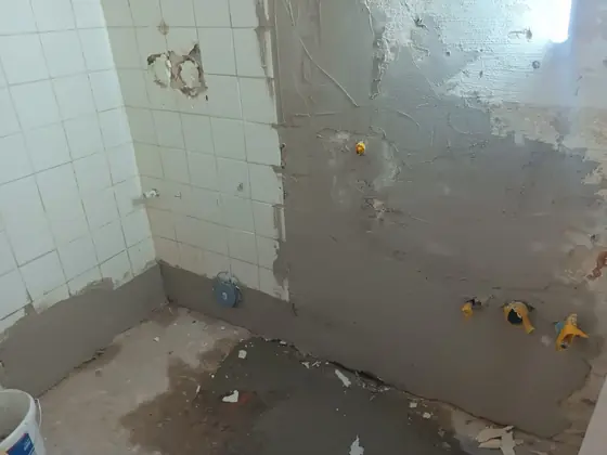 WC vor der Renovierung mit alten Fliesen und rohen Wandflächen